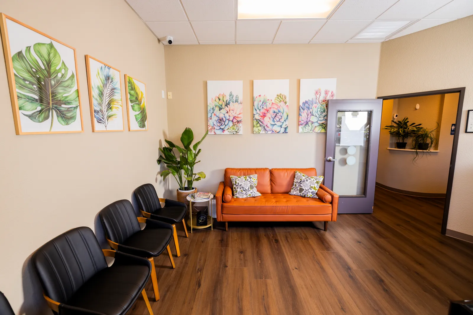 Comfortable waiting room with botanical wall art and modern seating