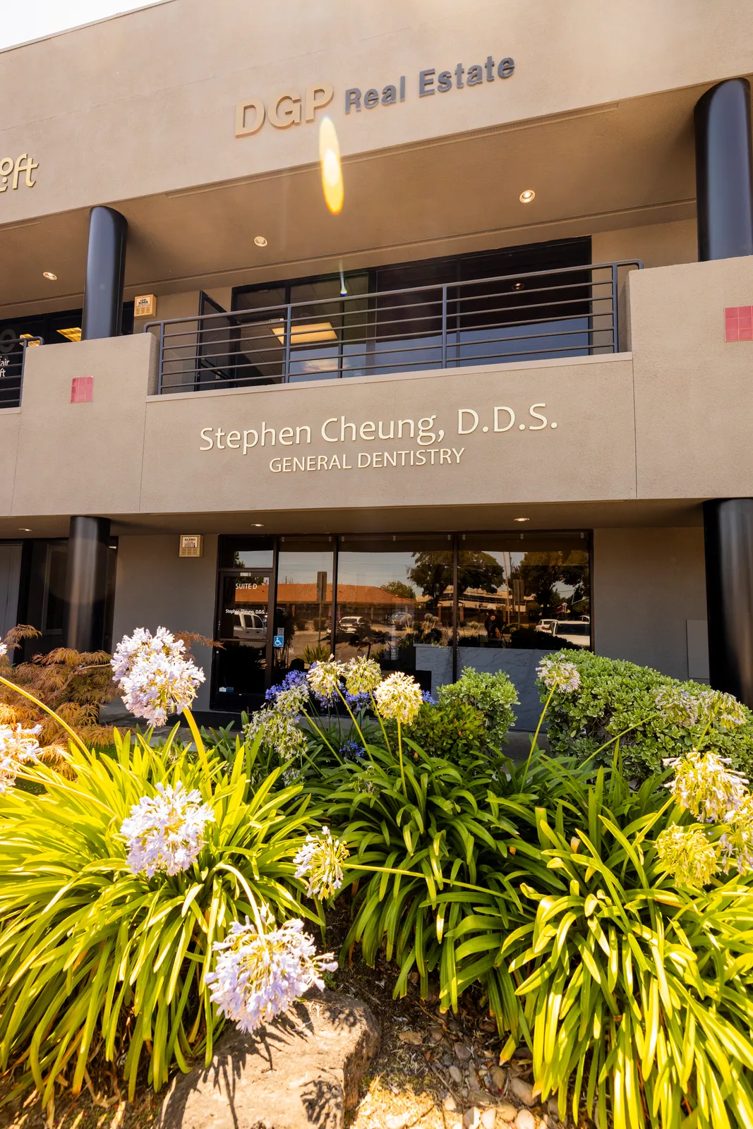 Welcoming entrance to Stephen Cheung DDS in Lodi, framed by a flowering garden