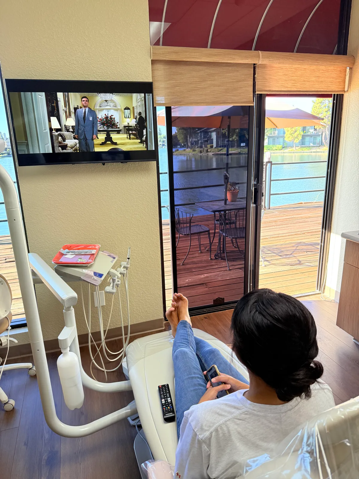 Patient relaxing in the treatment chair with a TV and lakeside deck view